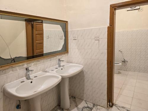 a bathroom with two sinks and a mirror and a toilet at دور مستقل خمس غرف في خميس مشيط مع حوش وسطوح in Khamis Mushayt