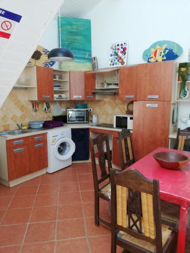 - une cuisine avec une table et des chaises rouges dans la chambre dans l'établissement Maison Sophie, à Saint-Julien-en-Born