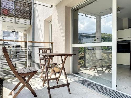 une table et des chaises en bois sur un balcon dans l'établissement Le Central-4 personnes-Parking, à Annemasse