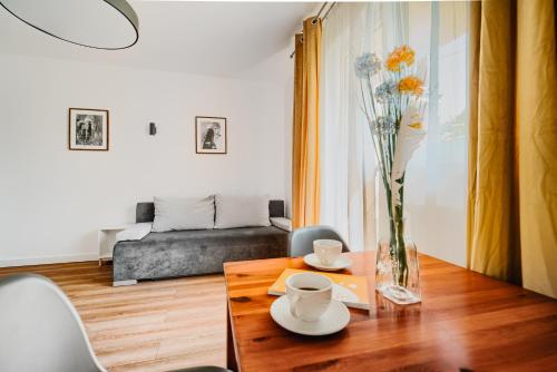 a living room with a table and a vase with flowers at Willa Mazowiecka Jantar in Jantar