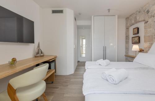 a hotel room with two beds and a chair at Casa Columba - 4 Star Design Boutique Hotel with Outdoor Pool & Private Garden in Makarska