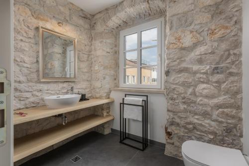 a stone bathroom with a sink and a window at Casa Columba - 4 Star Design Boutique Hotel with Outdoor Pool & Private Garden in Makarska