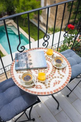 a table with oranges and a book on a balcony at Casa Columba - 4 Star Design Boutique Hotel with Outdoor Pool & Private Garden in Makarska