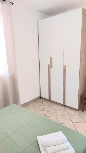 マリーナ・ディ・ペスコルーゼにあるLovely House risveglio fronte mareのベッドにタオルが置かれたワードローブが2つある部屋