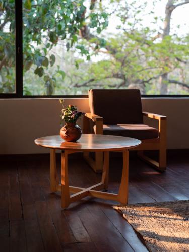 a living room with a table and a chair at La Paranera Hotel & Relax in Comala