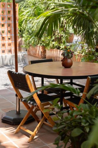 a table and chairs with a potted plant on a patio at La Paranera Hotel & Relax in Comala