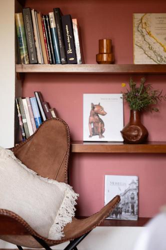 a chair in front of a book shelf with books at La Paranera Hotel & Relax in Comala