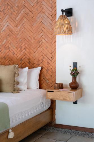 a bedroom with a bed and a table with a lamp at La Paranera Hotel & Relax in Comala