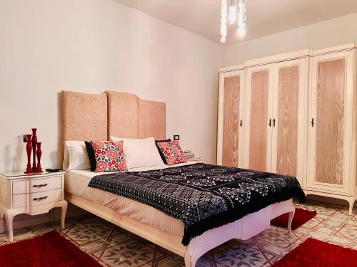 a bedroom with a large bed and a dresser at Ma Maison Gleem, Alexandria in Alexandria
