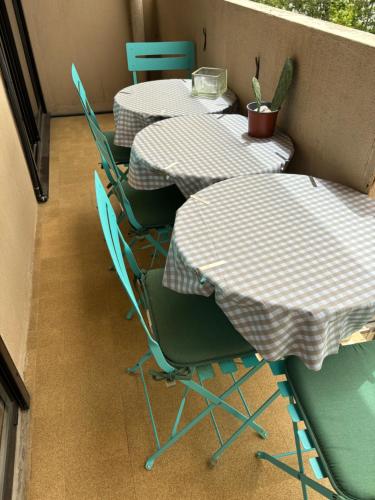 a row of tables and chairs sitting on a balcony at Ajaccio magnifique T2 40m2 centre ville vue mer au bord de la plage neuf 5 personnes Clim wifi balcon parking privé fermé in Ajaccio