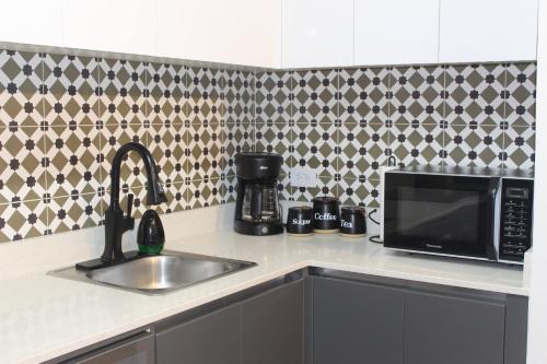 a kitchen counter with a sink and a microwave at Departamento en Casco Antiguo in Panama City