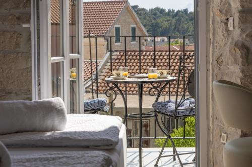a room with a balcony with a table and chairs at Casa Columba - 4 Star Design Boutique Hotel with Outdoor Pool & Private Garden in Makarska