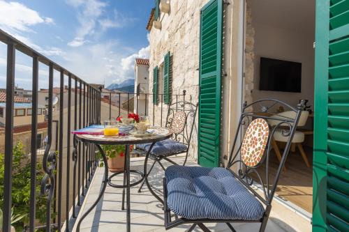 a patio with a table and chairs on a balcony at Casa Columba - 4 Star Design Boutique Hotel with Outdoor Pool & Private Garden in Makarska