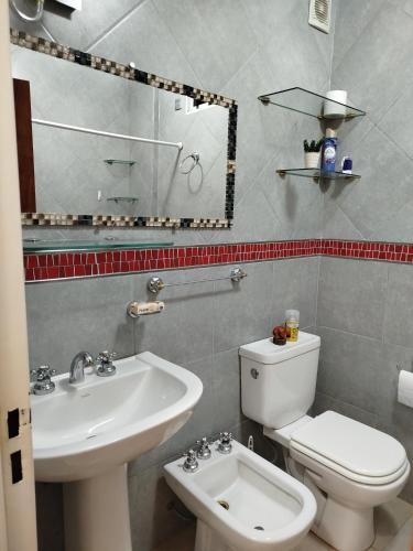 a bathroom with a white toilet and a sink at Camba Cua Relax in Corrientes