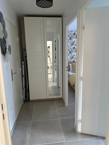 un couloir avec un miroir et une chambre avec un lit dans l'établissement 6Personne,10mn de disney,30mn de paris,parking, à Bussy-Saint-Georges