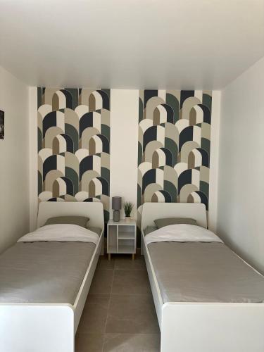 Cette chambre comprend 2 lits et une fresque murale. dans l'établissement 6Personne,10mn de disney,30mn de paris,parking, à Bussy-Saint-Georges