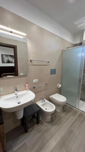 a bathroom with a sink and a toilet and a mirror at Jenka in Caltabellotta