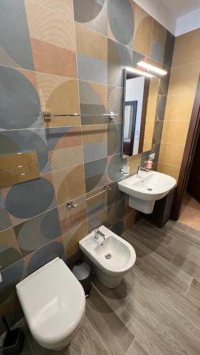 a bathroom with two sinks and a toilet and a mirror at Jenka in Caltabellotta