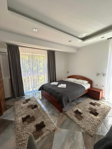 a bedroom with a bed and two rugs at Vila Markovic-a in Soko Banja