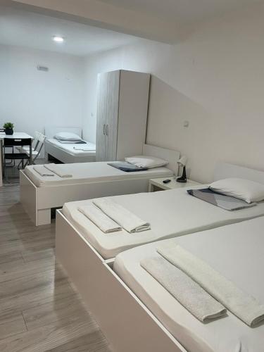 a room with three beds in it with a table at TIKI Apartments in Gevgelija