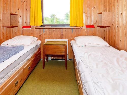 two beds in a room with a table and a window at 6 person holiday home in Spøttrup-By Traum in Lihme