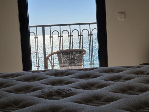 a bed with a view of a window with a chair at Vienna Luxury Apartments in Dobra Voda