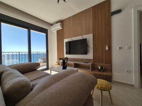 a living room with a couch and a flat screen tv at Vienna Luxury Apartments in Dobra Voda