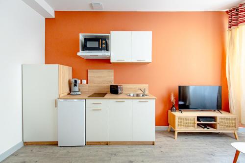 Una cocina con un refrigerador blanco y un microondas. en La Panthère d'Auch "By Cottage d'Auch", en Auch