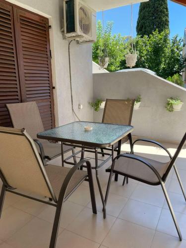 a glass table and chairs on a balcony at TIKI Apartments in Gevgelija