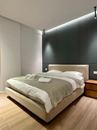 a bedroom with a large bed with a black headboard at SUV ApartHotel in Pogradec