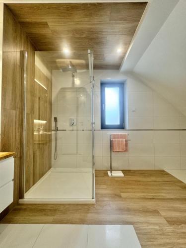 a large bathroom with a shower and a window at GrandBytyń House in Nakielno