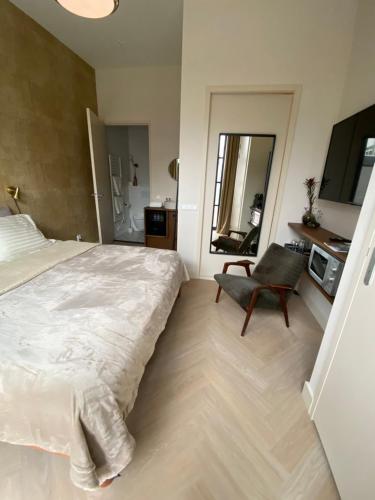 a bedroom with a large bed and a chair at Gorgeous room near Haarlem Station, city center in Haarlem