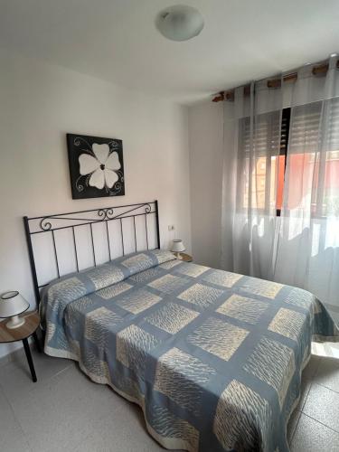 a bedroom with a bed with a blue and white comforter at La caleta in Oropesa del Mar