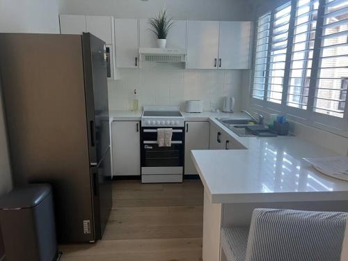 a kitchen with a refrigerator and a stove top oven at Sunny boutique apartment in Sydney