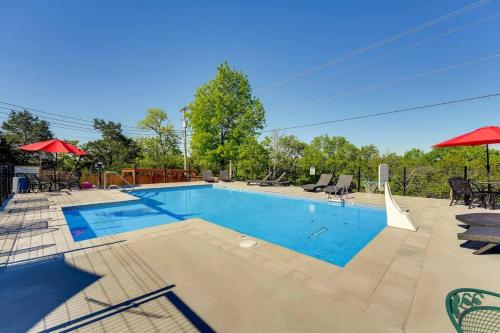 a large swimming pool with chairs and umbrellas at Indian Point Cabin 2 near SDC, Branson, and Table Rock Lake in Branson