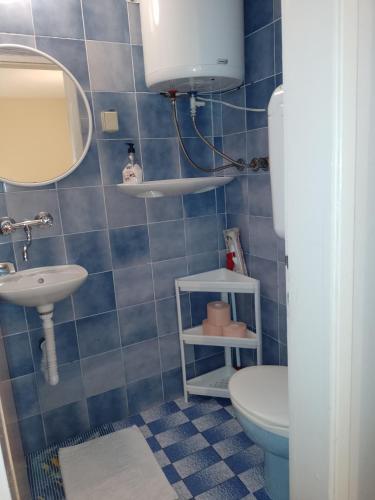 a blue tiled bathroom with a toilet and a sink at Double Room Sucuraj 6734b in Sućuraj