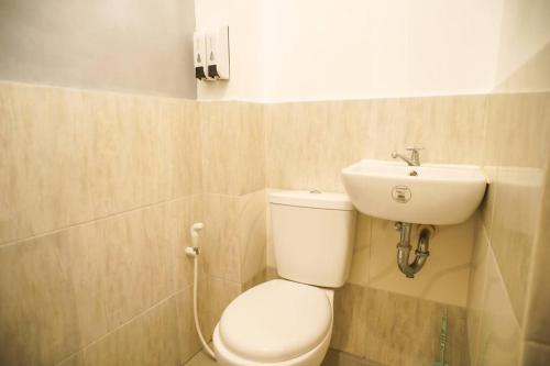 a bathroom with a toilet and a sink at Cozy Loftbed Wi-Fi & Netflix Along Ligao Natl Road Unit 309 in Ligao