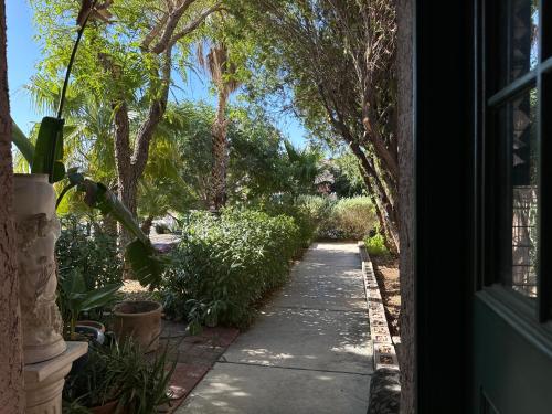a walkway leading into a yard with trees at The Monet- One bedroom with a private entrance - shared bathroom in Las Vegas