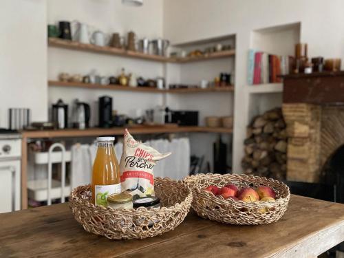 two baskets of food and a bottle of sauce on a table at Maison historique au cœur de Nogent-le-Rotrou, 6 chambres, piscine chauffée, idéal pour familles et amis - FR-1-581-121 in Nogent-le-Rotrou