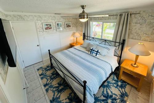 a bedroom with a bed and a window at Palme Bleu in Vero Beach
