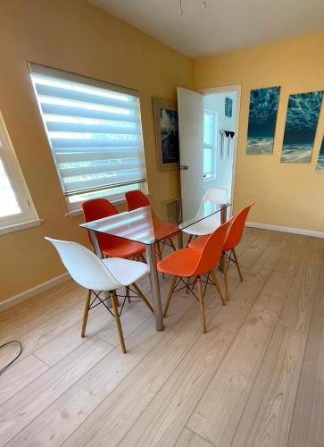 a dining room with a table and red chairs at Casa Pacifica - BBQ, Firepit, Walk to tons of fun places in San Diego