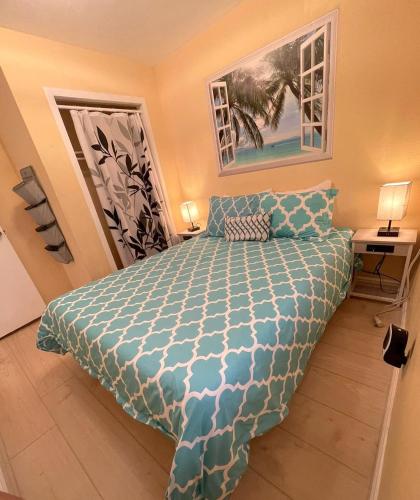 a bedroom with a bed with a blue comforter at Casa Pacifica - BBQ, Firepit, Walk to tons of fun places in San Diego