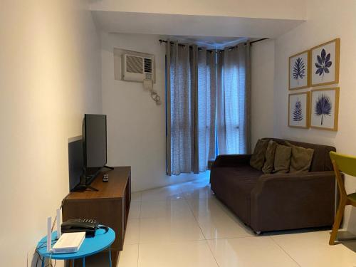 a living room with a couch and a television at Roxas Blvd Stunning Studio Condo Near US Embassy in Manila