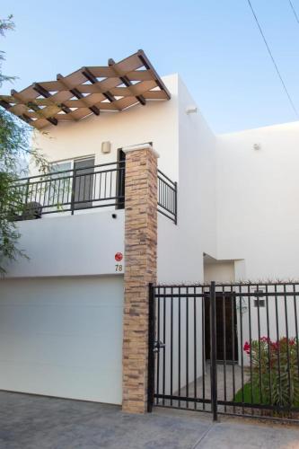 a white house with a gate and a fence at Rocky point beach house. in Puerto Peñasco