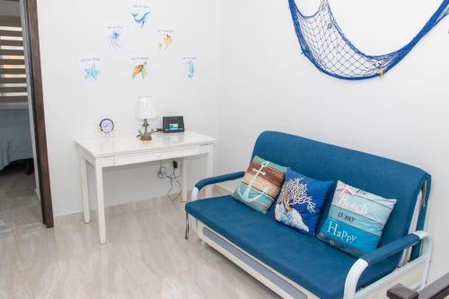 a blue chair in a room with a white wall at Rocky point beach house. in Puerto Peñasco