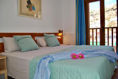 a bedroom with a bed with flowers on it at Montecarlo 35 or 45 first row with air conditioning & WI-FI & sound insulation in Puerto Rico de Gran Canaria