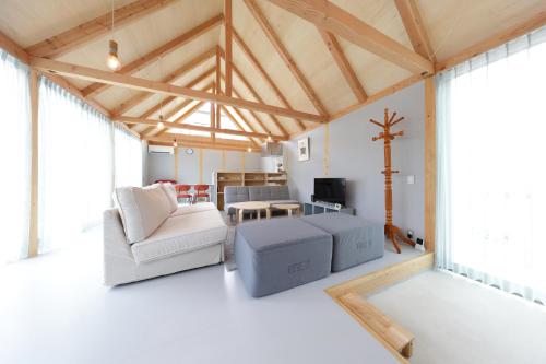 a living room with white furniture and a cross on the wall at Soleil MIURA in Miura