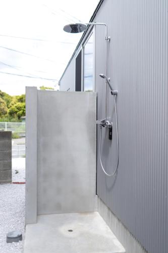 a bathroom with a shower in the side of a building at Soleil MIURA in Miura