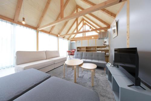 a living room with a couch and a tv at Soleil MIURA in Miura