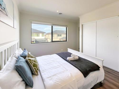 a bedroom with a large white bed with a window at Modern Berwick Home with Fast WiFi Garage in Berwick